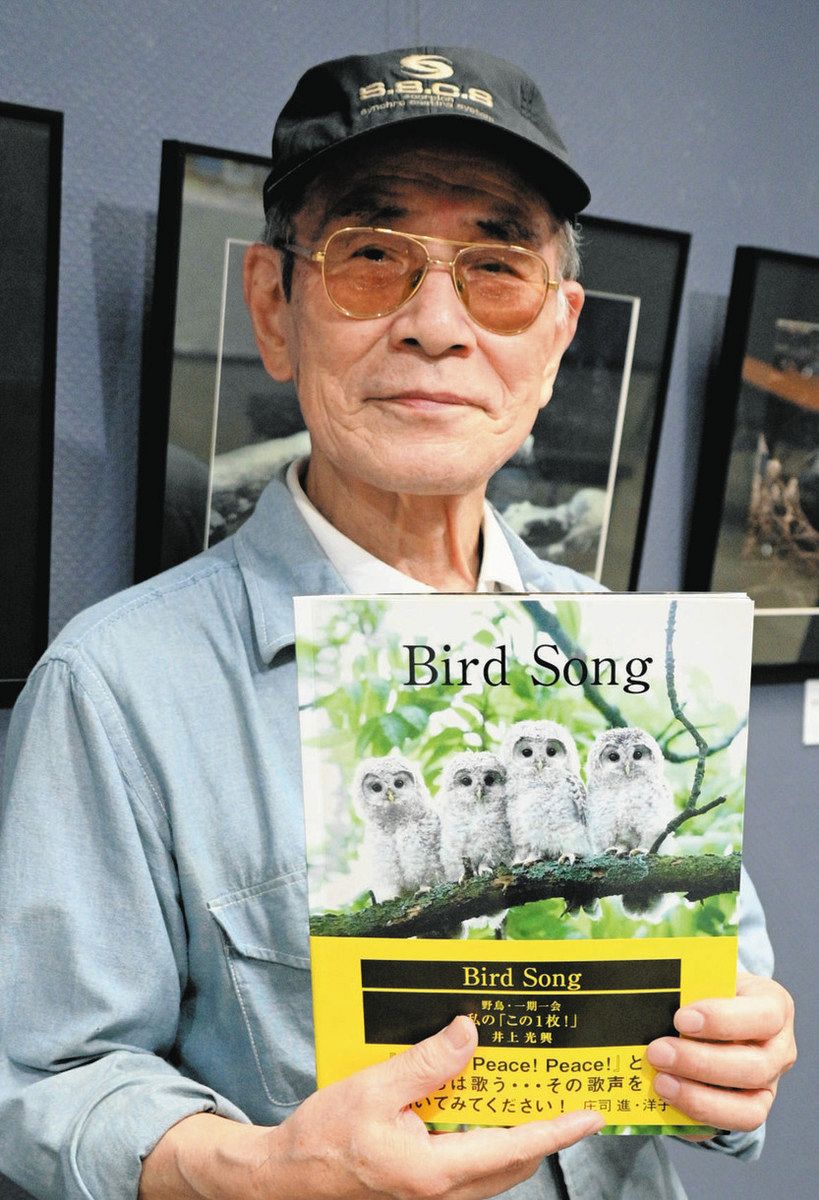 写真集「Bird Song」を手にする井上光興さん＝調布市で 