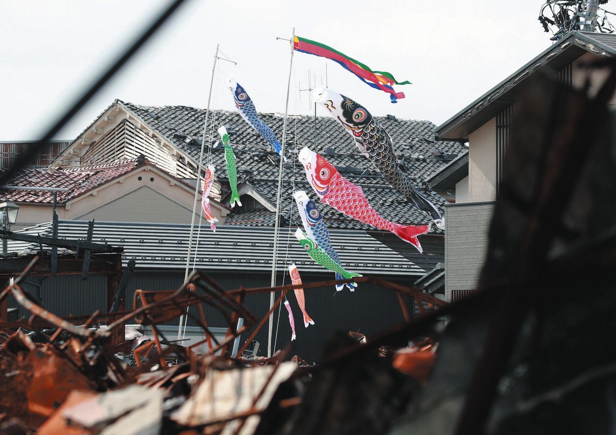 被災の跡が残る朝市通りに掲げられたこいのぼり＝20日、石川県輪島市河井町で