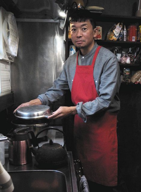 開発したエプロンを着けて自宅の台所に立つ吉原さん＝いずれも鎌倉市で
