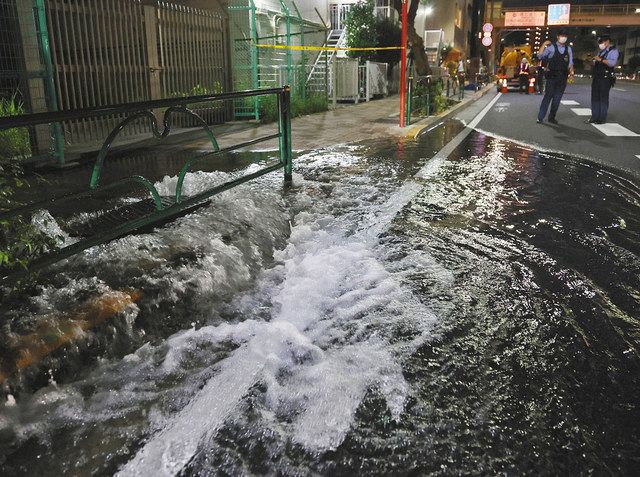 地震の影響でマンホールからあふれ出した水＝７日午後１１時４２分、東京都目黒区で 