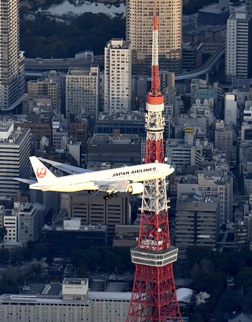 羽田新ルートの飛行確認のため、東京上空を飛行する旅客機。奥は東京タワー＝東京都内で、本社ヘリ「おおづる」から（安江実撮影）