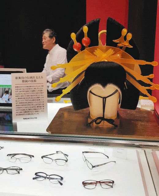 眼鏡展示会での「長井」ブース。高橋さん（写真奥）がお礼としてかつらを結って届けた＝２０１５年１０月