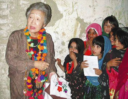 ２０００年９月、パキスタンのアフガニスタン難民キャンプで、子供たち手作りのハンカチを受け取る緒方貞子国連難民高等弁務官＝ロイター・共同