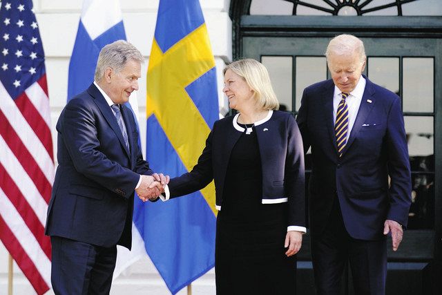 19日、米ホワイトハウスで、バイデン大統領（右）が見守る中、スウェーデンのアンデション首相（中）と握手するフィンランドのニーニスト大統領＝AP