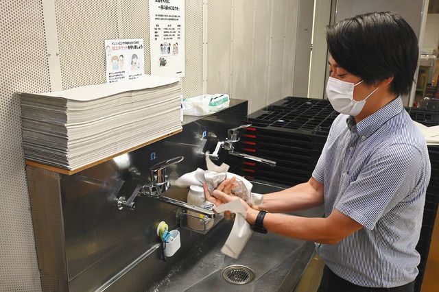 細長く切った白い損紙（左上）が置かれた手洗い場＝いずれも埼玉県戸田市の埼京オフセットで