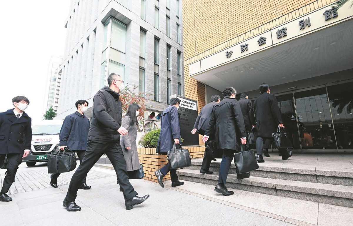 家宅捜索のため自民党二階派（志帥会）の事務所に向かう東京地検特捜部の係官ら＝昨年12月19日、東京都千代田区で