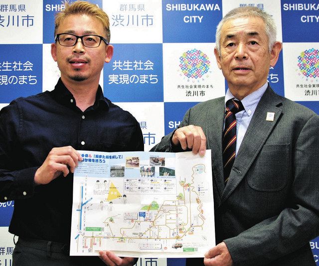 観光マップを紹介する佐藤会長（右）と木村さん＝渋川市で
