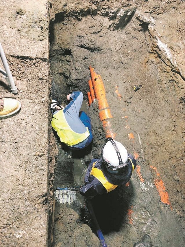 送電管を貫通させた穴を確認する東京電力職員ら＝17日、川崎市麻生区で（同市提供）