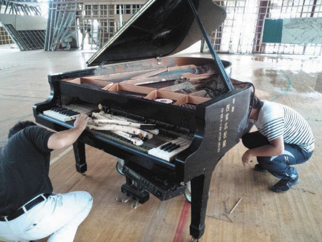 津波で水没した豊間中学校のピアノ。寄贈者の名前が書かれている＝２０１１年、いわき市で（遠藤洋さん提供）
