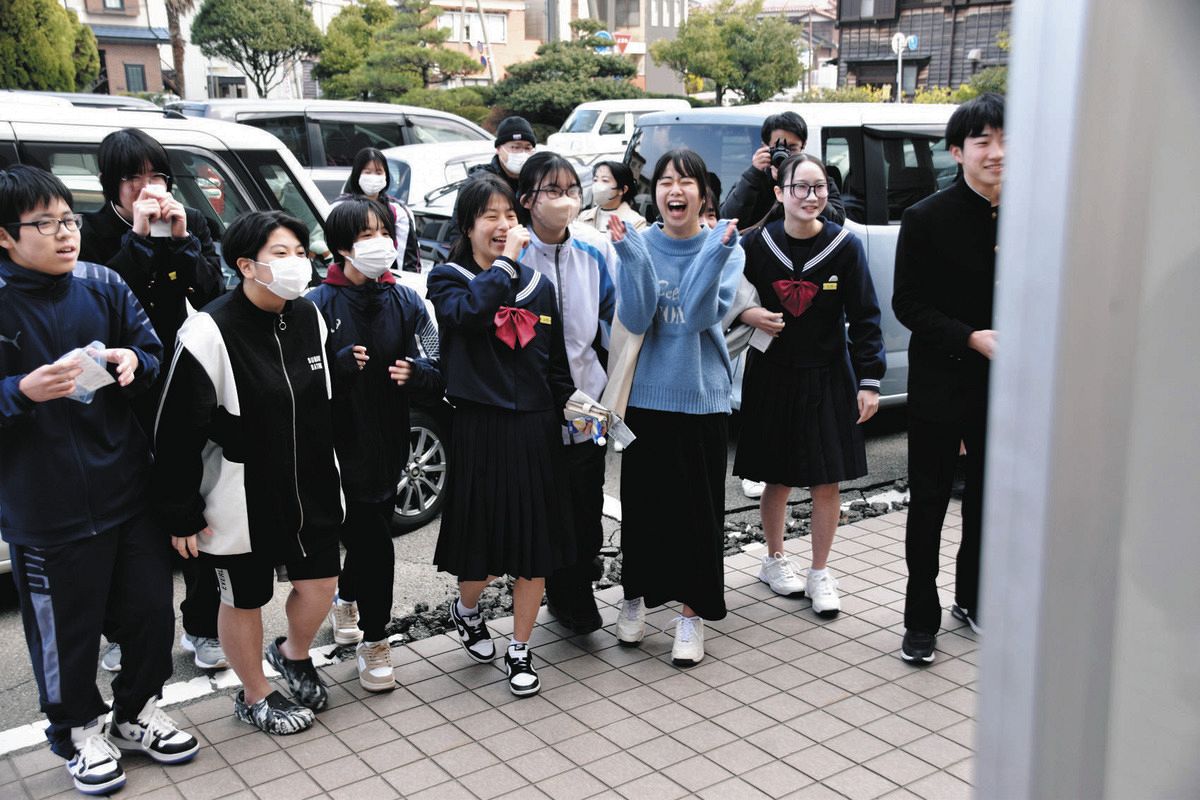 自分の受験番号を見つけ、喜ぶ中学生ら＝14日、石川県輪島市河井町の輪島高校で