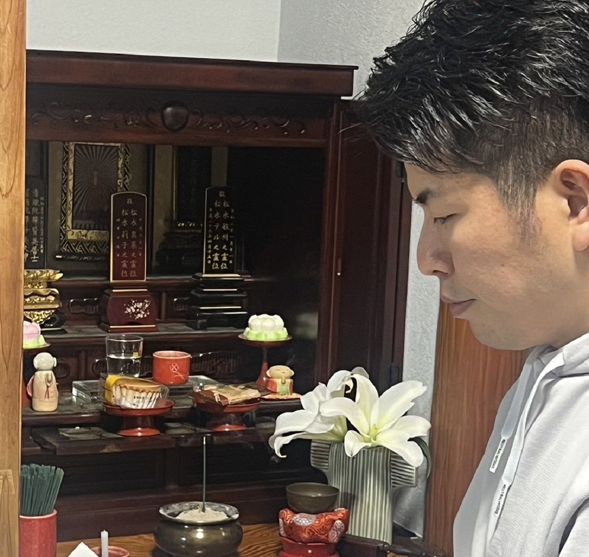 仏壇に向かい、松永真菜さん、莉子ちゃんに報告をした松永拓也さん＝6日、東京都豊島区で