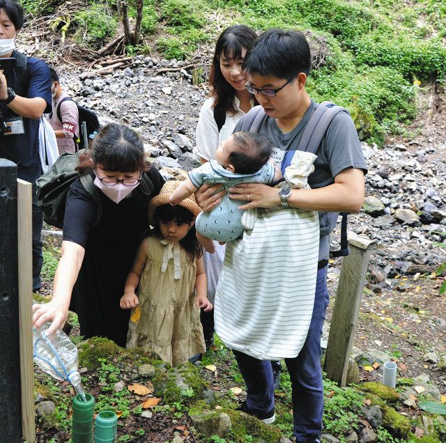 今年4月に産まれた長男を連れて墓標に向かう若本さん一家＝12日、群馬県上野村で