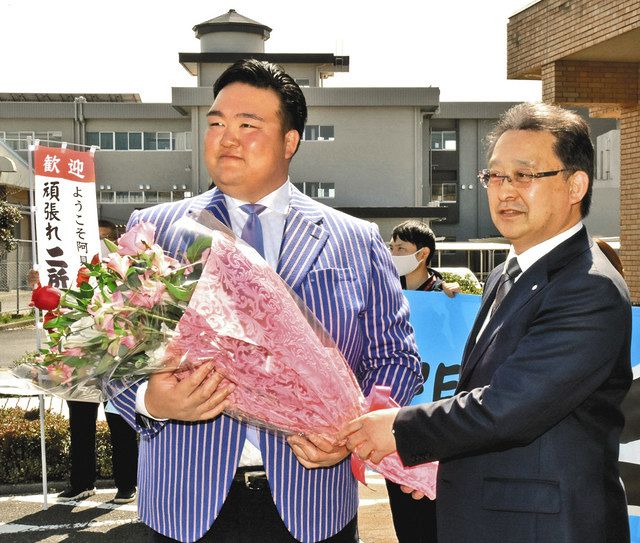 千葉繁町長（右）から歓迎の花束を受け取る二所ノ関親方＝いずれも阿見町で 