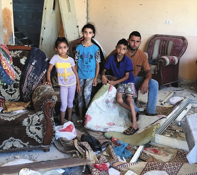 ７月末、パレスチナ自治区ガザで、５月のイスラエルの空爆で自宅を吹き飛ばされた家族。家財は散乱したままだ