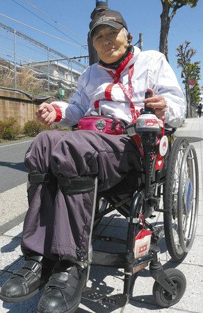 「苦しむ患者がいることを知ってほしい」と話す富田真也さん。病気への配慮を求める「ヘルプマーク」を体や車いすなどにいくつもつけている＝１４日、東京都中野区で（中村真暁撮影）