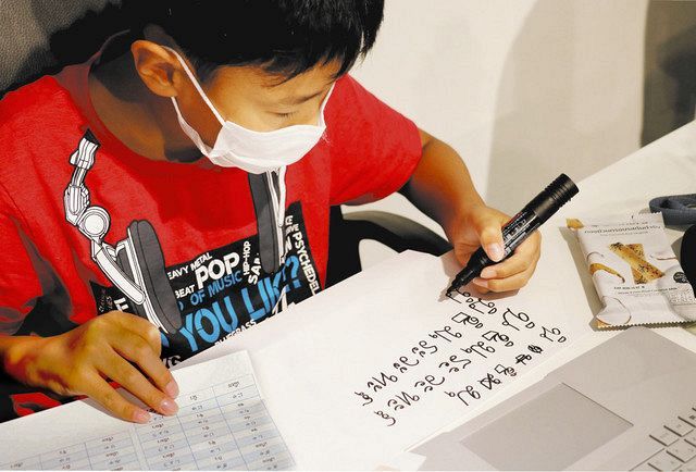 タイ字表を見ながら自分の名前をタイ語で書く児童