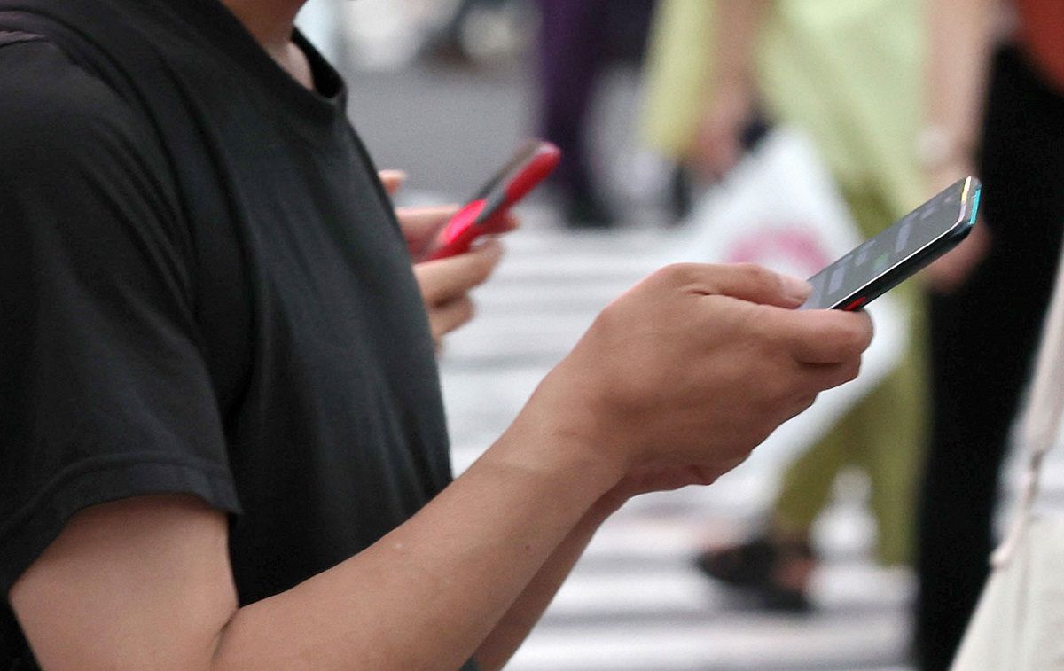 スマートフォンを手にする男性（資料写真）