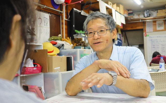 勤務先の福祉サービス事務所で利用者と話す藤井さん＝横浜市磯子区で 