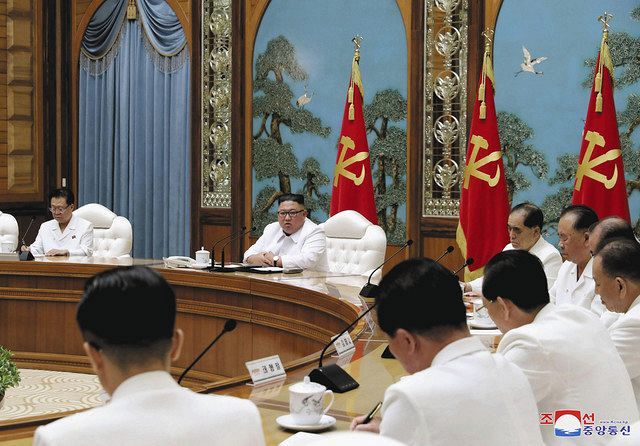 ２５日、北朝鮮・平壌で開かれた朝鮮労働党の政治局非常拡大会議に出席した金正恩党委員長（奥左から２人目）＝朝鮮中央通信・共同