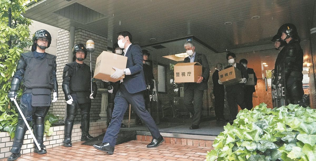 家宅捜索を終え、段ボールを手につばさの党の事務所が入る建物を出る捜査員ら＝13日、東京都千代田区で