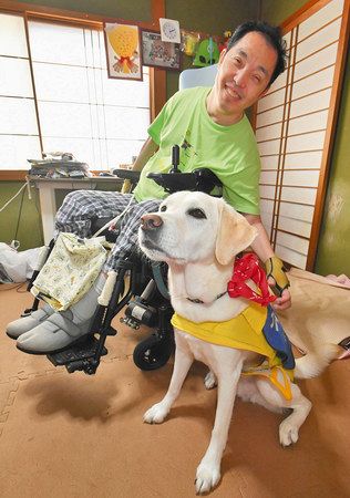病院への入室を拒否された平野友明さんと介助犬のタフィー＝金沢市で
