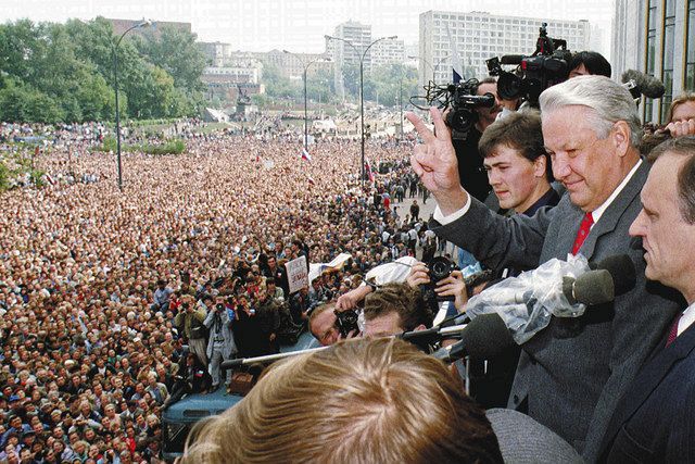 １９９１年８月２２日、モスクワで、保守派クーデターの失敗を受け、エリツィン大統領（右から２人目）は、ロシア共和国ビルのバルコニーから、集まった多数の市民にＶサインをして応じた＝ＡＰ