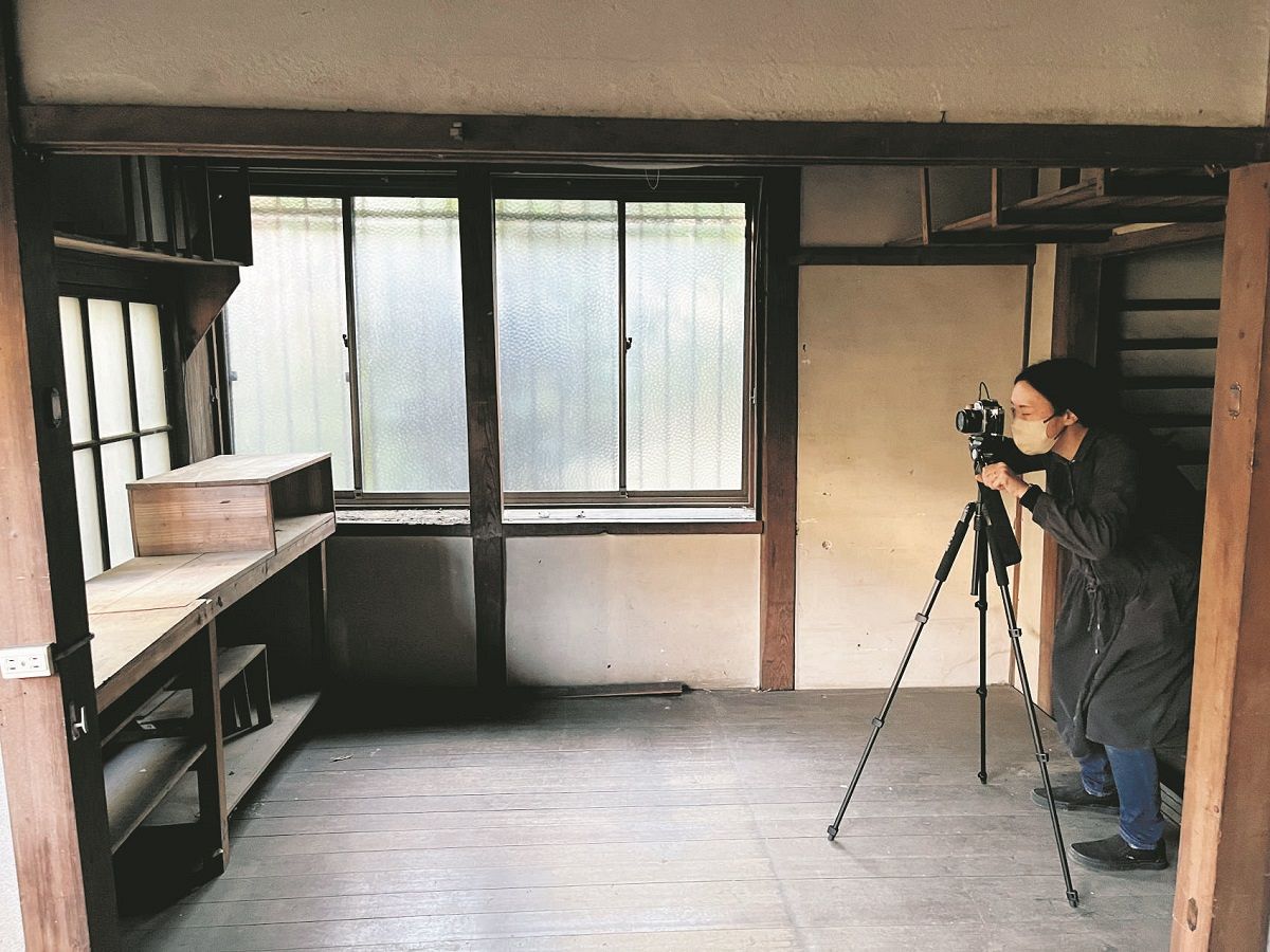 自作の題材としてアトリエ内部を撮影する美術家の鈴木のぞみさん＝2023年11月
