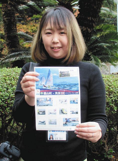 「葉山港沖のセーリング風景」の写真が使われたフレーム切手を手にする宮崎愛子さん＝神奈川県葉山町で