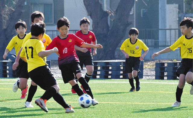 完成したばかりの人工芝グラウンドでサッカーを楽しむ朝鮮学校と地元の児童ら。赤いユニホームが朝鮮学校のチーム