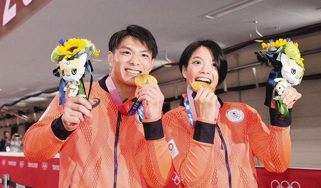 兄と妹そろっての同日優勝を果たし、金メダルをかじる阿部一二三（左）と妹の詩 ＝いずれも日本武道館で