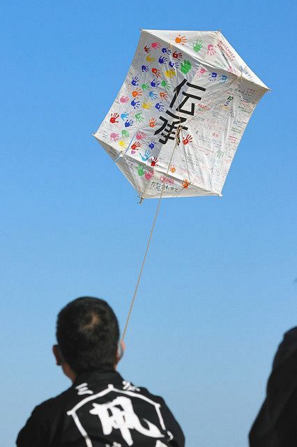 東日本大震災・原子力災害伝承館で開催された「大凧揚げ」で青空に舞い上がる県内の子どもたちのメッセージが書かれたたこ＝１０日、福島県双葉町で