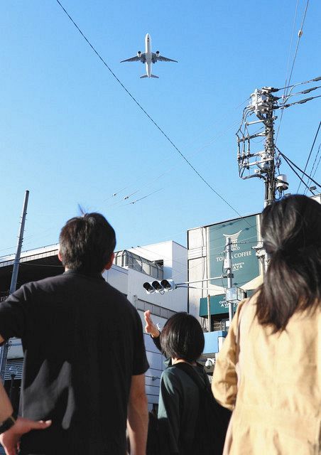 羽田空港の新飛行ルートで大井町駅周辺上空を飛行する航空機＝昨年１０月、東京都品川区で