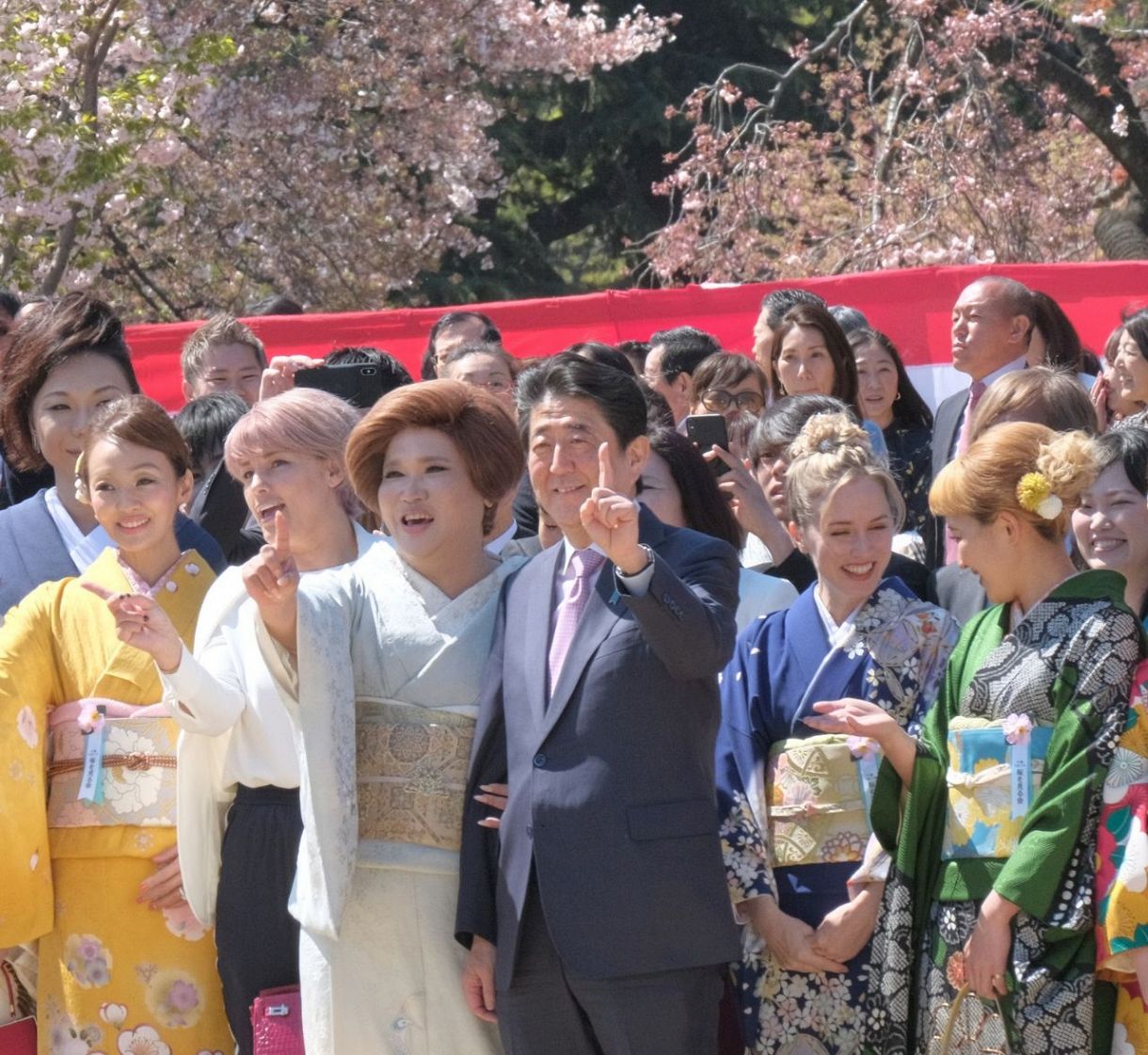 「桜を見る会」で招待客と記念撮影する安倍晋三元首相＝2019年4月