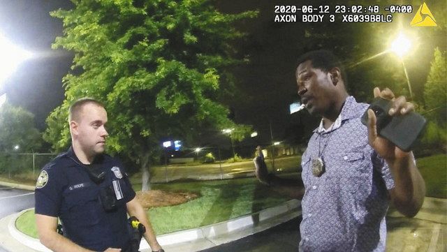 米ジョージア州アトランタで１２日、警官と話をするレイシャード・ブルックスさん（右）＝アトランタ警察提供、ＡＰ・共同
