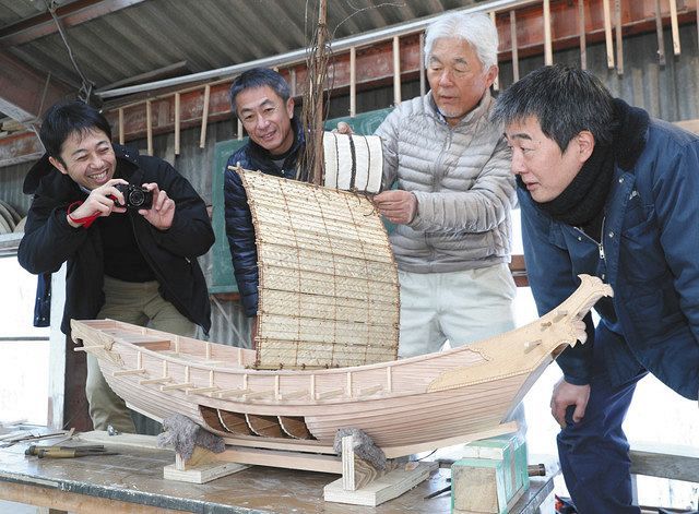 製作が進む遣唐使船の模型と岡村造船所の関係者ら=静岡県松崎町の岡村造船所で(山田英二撮影)