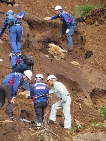 大雨で土砂崩れが発生した現場を調べる国土交通省の専門家ら＝１０月３１日、千葉市緑区誉田町で