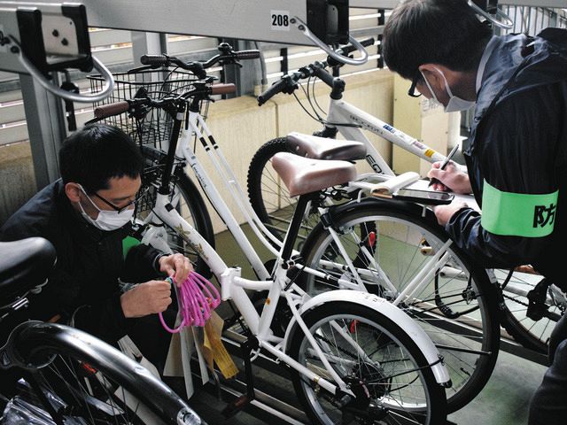 無施錠の自転車にワイヤ錠を巻いていく警視庁蒲田署員ら＝東京都大田区で