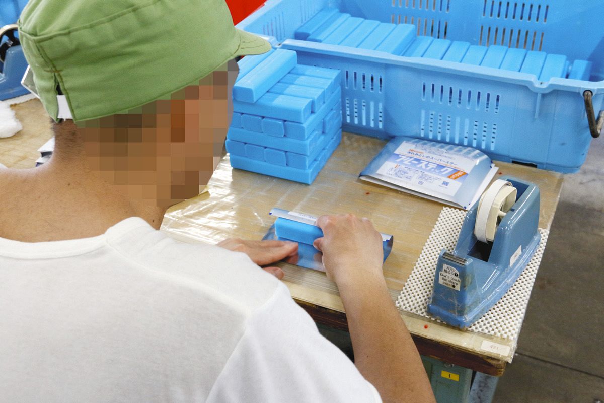 ブルースティックを包装する受刑者（一部画像処理）