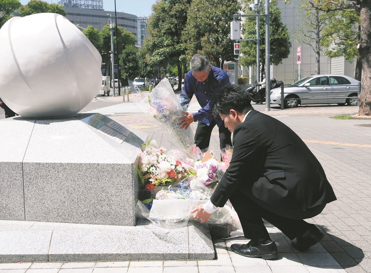 Takuya Matsunaga (front) and Yoshinori Uehara lay flowers at a memorial near the accident site on the 19th in the Toshima district of Tokyo.