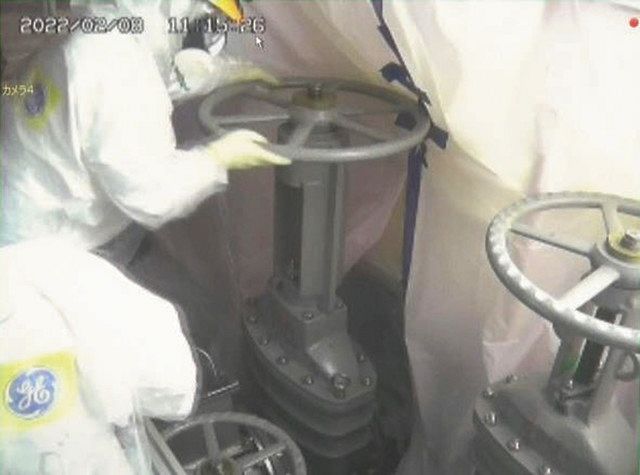 ロボットを入れるため、1号機原子炉格納容器に通じる弁を開ける作業員（国際廃炉研究開発機構、日立GEニュークリア・エナジー提供）