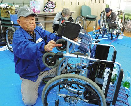 車いすを整備する櫛野浩一さん（手前）らボランティアの会のメンバー＝東京都江東区で