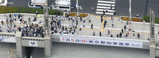 東京都知事選が告示され、候補者の第一声を聞く有権者ら＝１８日、東京都内で、本社ヘリ「まなづる」から
