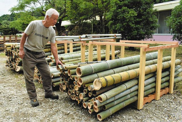住民らから買い取った竹を前に「放置竹の循環利用を進める」と話す鹿嶋理事長