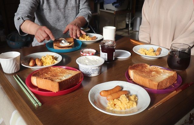 家族の朝食は平日はばらばらだが、週末はこたつで少女と両親、妹が4人そろって食べる