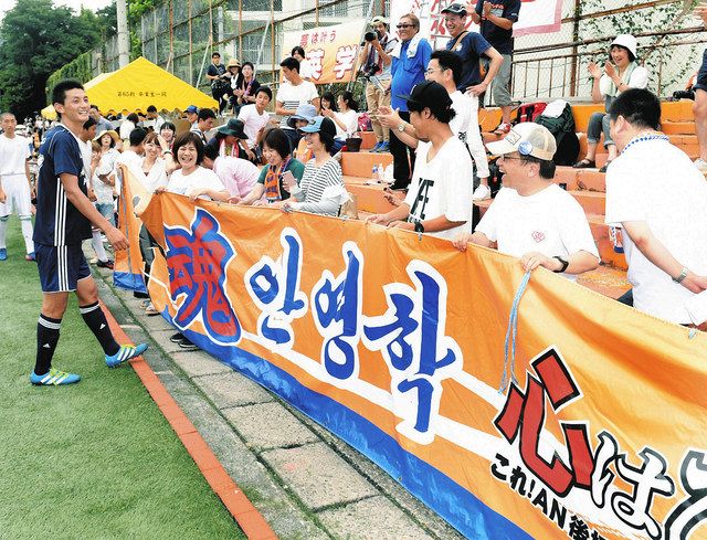 은퇴 경기를 마친 후 에이가쿠 야스(왼쪽)가 2017년 기타구 도쿄 한국 고등학교에서 전 소속팀인 J1 니가타 팬들이 배너를 건네는 모습을 보며 웃고 있다.