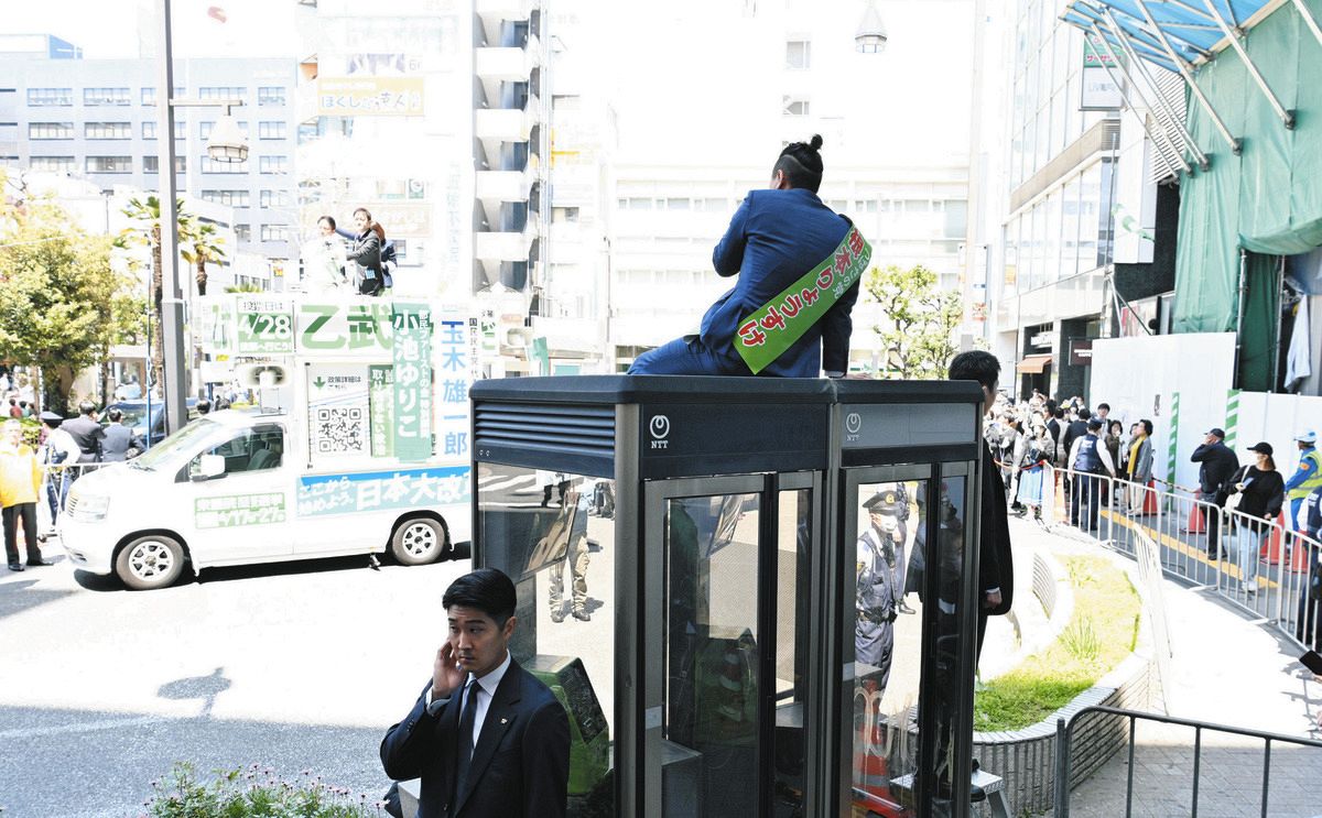Fecha de aviso para las elecciones especiales para la Cámara de Representantes del Distrito 15 de Tokio.Sr.  Nemoto, Sr.  Hablando desde lo alto de una cabina telefónica pública durante un discurso del bando de Ototake.