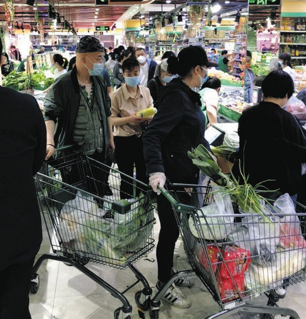 ２５日、北京市内のスーパーで、ロックダウンを警戒し生鮮食料品などの買いだめに走る市民ら