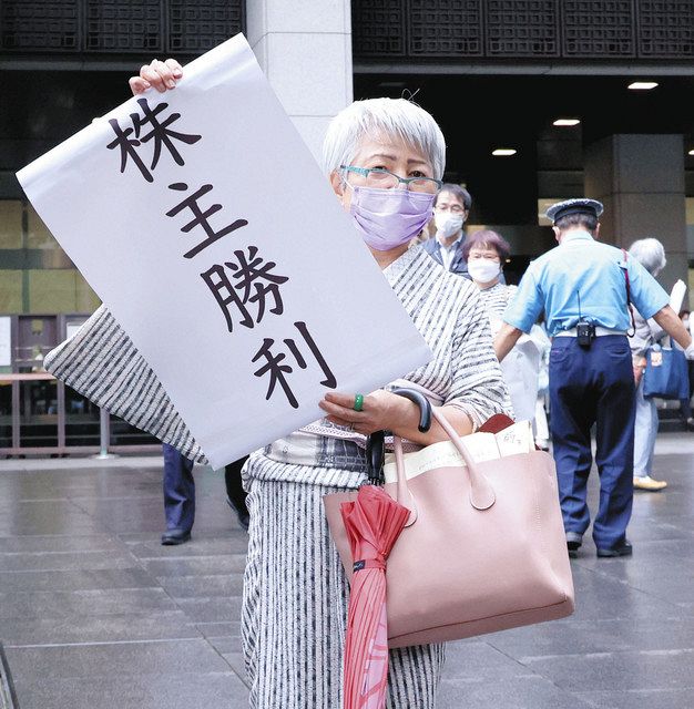 判決後、「株主勝利」と書かれた紙を広げる原告の木村結さん