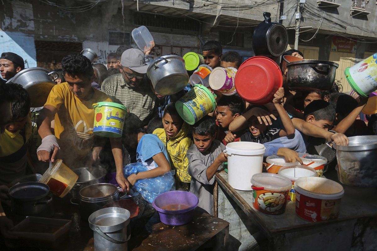 イスラエルとハマスの衝突で深刻な人道危機に瀕しているガザ地区。南部ラファでは食料の配給に人が押し寄せた＝AP