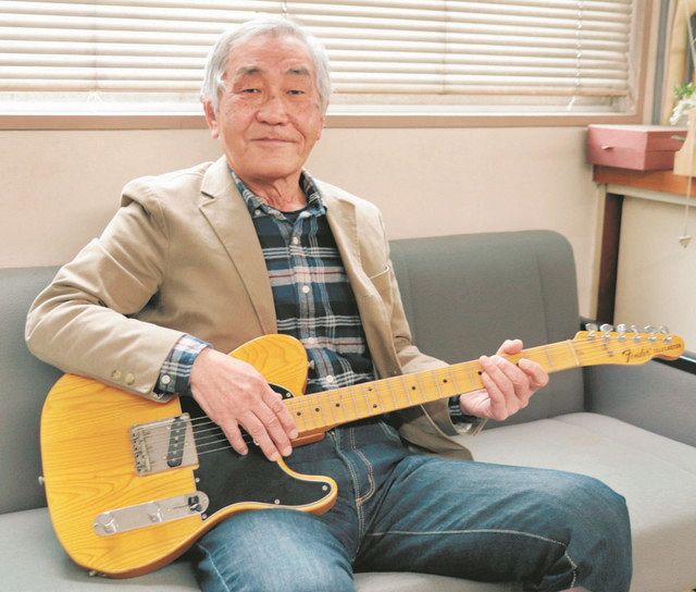 尾崎さんが練習用に使っていたギターを手に持つ榊原さん＝愛知県半田市で
